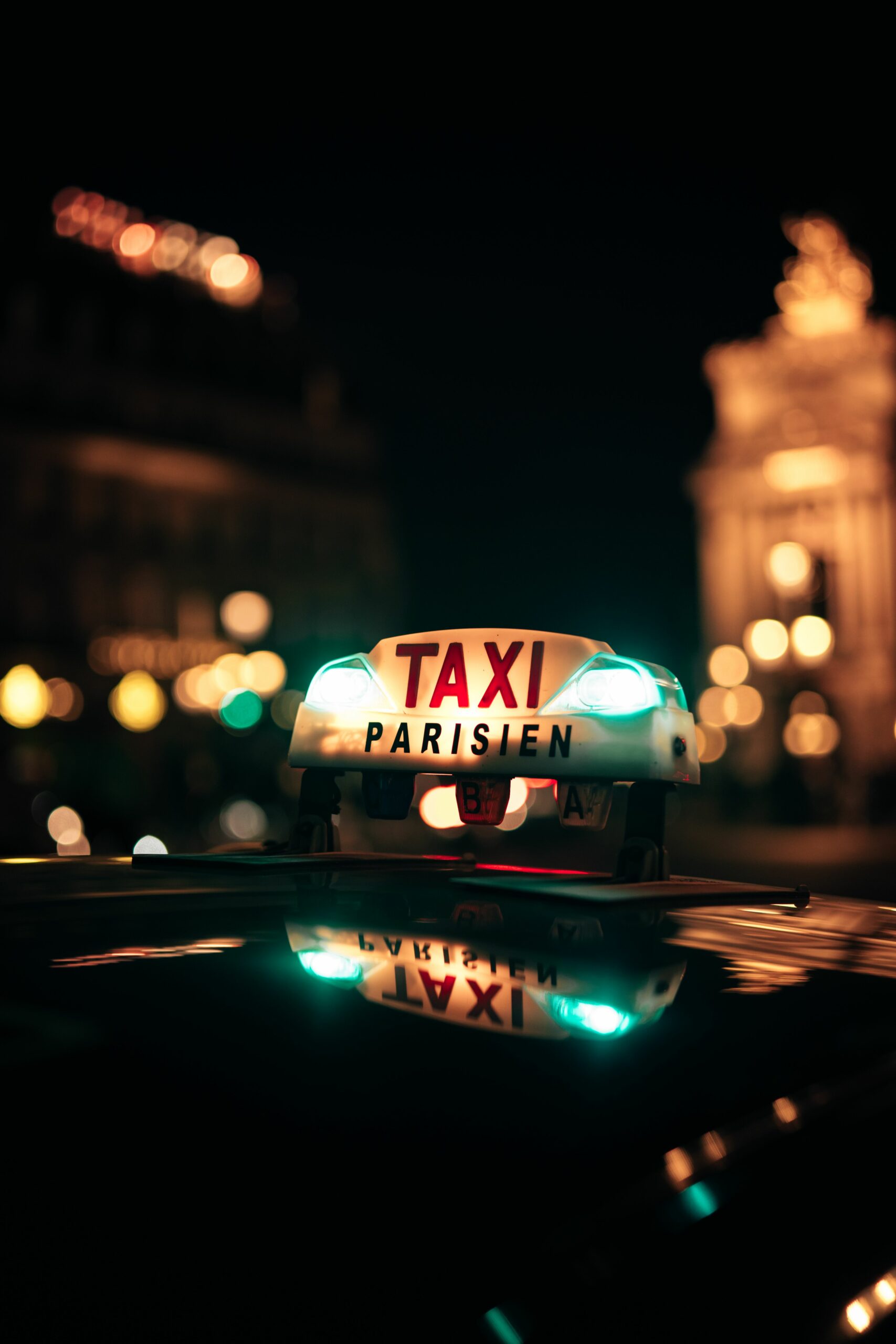 Illuminated taxi sign in Paris streets at night with Opera Garnier nearby. Vibrant city lights.
