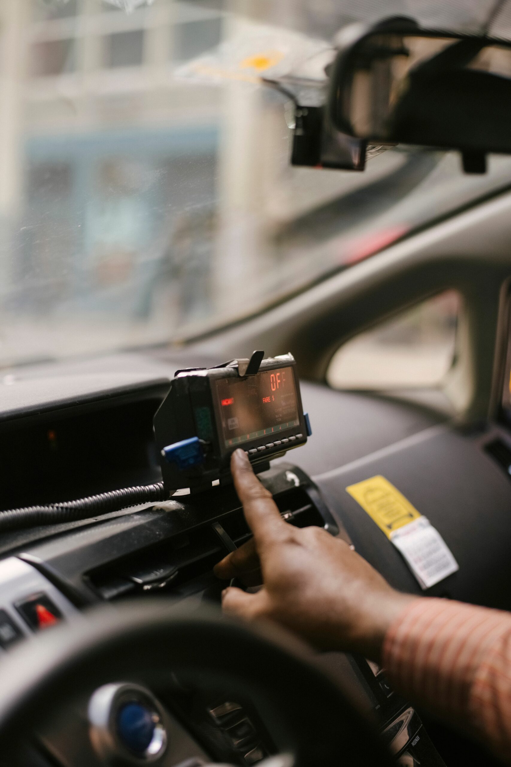 Home Unrecognizable ethnic male driver sitting in cab with blurred background and using navigator to find way to drive during ride